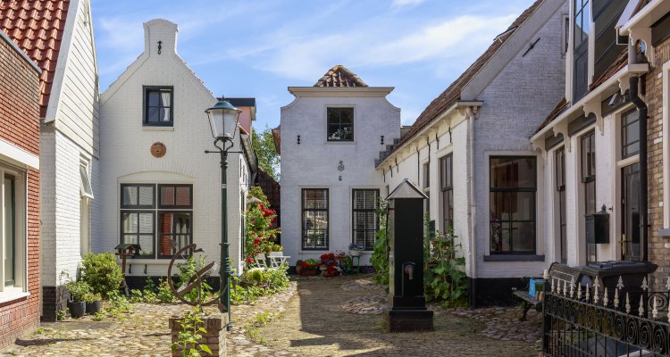 Old and picturesque houses, buildings and architecture typical in downtown Den Burg village on the wadden island Texel on a sunny day in Summer