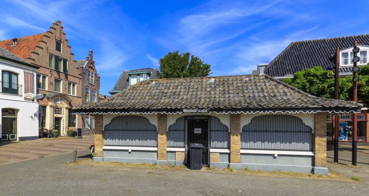 Public restroom, old and picturesque houses, buildings and architecture typical on a shopping street in Den Burg on the wadden island Texel during a sunny day in Summer