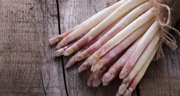 Bunch of fresh white asparagus on old wooden board