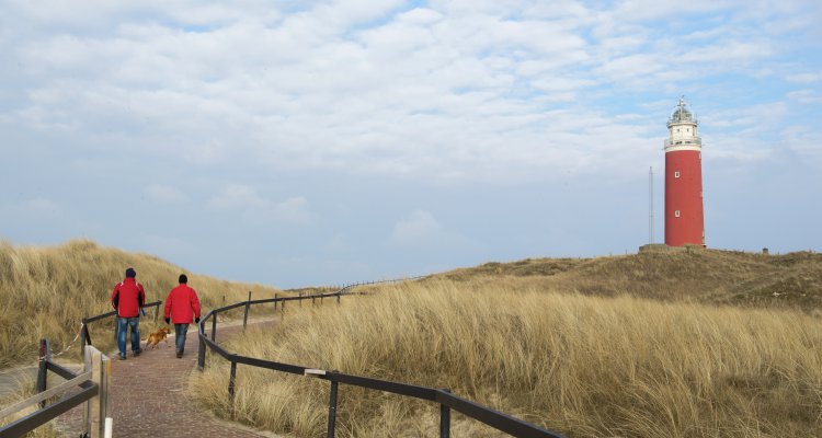 Two man are walking to red lighthouse