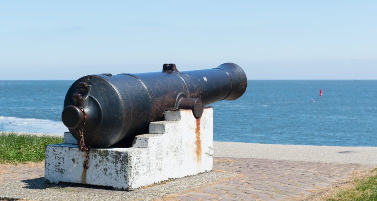 Old metal cannon at sea